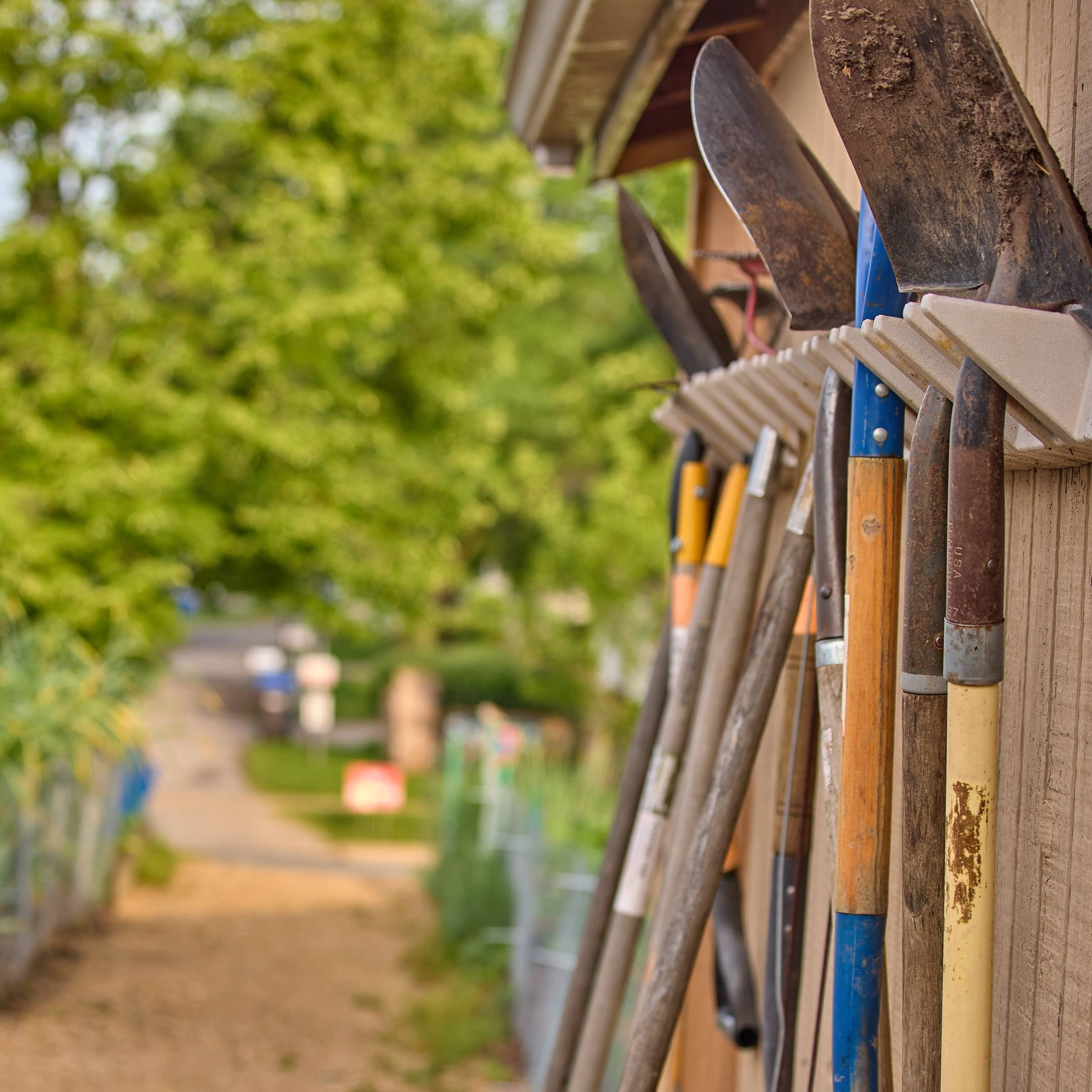 Photographs of gardening tools at two different depths of field, one with more focus on the tools in the foreground.